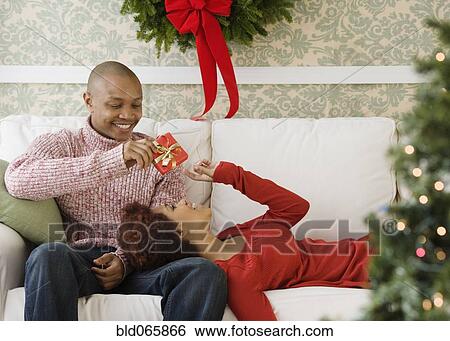 African man giving girlfriend Christmas present View Large Photo Image Stock Photograph - African man giving girlfriend Christmas present. Fotosearch