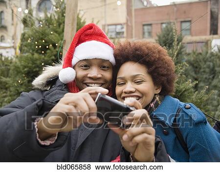 African man in santa hat taking self-portrait with girlfriend View Large Photo Image Stock Photo - African man in santa hat taking self-portrait with girlfriend. Fotosearch