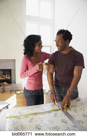 African man measuring wall paper with wife View Large Photo Image Stock Image - African man measuring wall paper with wife. Fotosearch