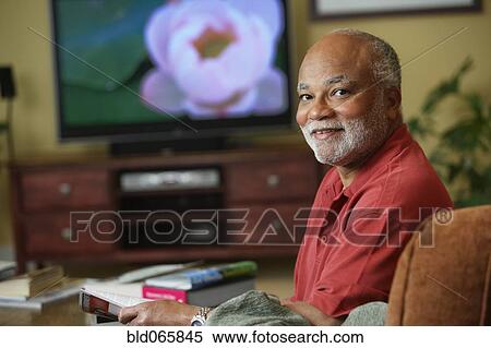 African man watching television in livingroom View Large Photo Image Stock Photography - African man watching television in livingroom. Fotosearch