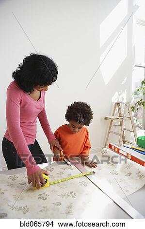 African mother teaching son to measure wallpaper View Large Photo Image Picture - African mother teaching son to measure wallpaper. Fotosearch