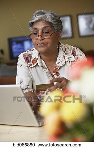 African woman ordering merchandise online with credit card View Large Photo Image Stock Image - African woman ordering merchandise online with credit card. Fotosearch