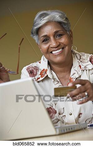 African woman ordering merchandise online with credit card View Large Photo Image Stock Image - African woman ordering merchandise online with credit card. Fotosearch