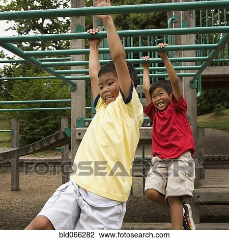 Asian boys crossing monkey bars on playground View Large Photo Image Stock Image - Asian boys crossing monkey bars on playground. Fotosearch