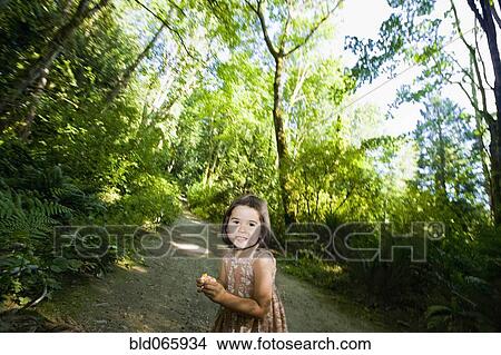 Picture - Chinese girl walking along remote wooded path. Fotosearch