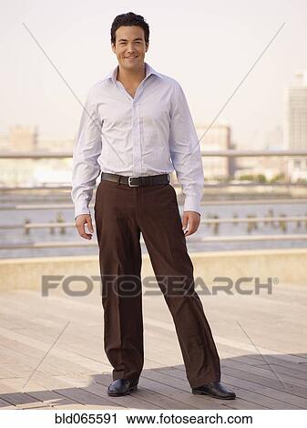 Confident man standing on boardwalk at waterfront View Large Photo Image Stock Image - Confident man standing on boardwalk at waterfront. Fotosearch