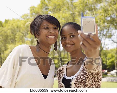 Stock Photo - Friends taking self-portrait with cell phone. Fotosearch