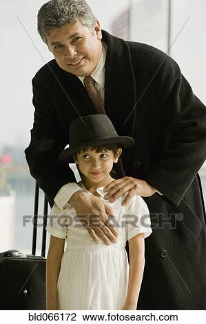 Hispanic father hugging daughter in airport View Large Photo Image Stock Image - Hispanic father hugging daughter in airport. Fotosearch