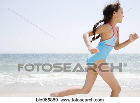 Stock Photo - Hispanic girl running on beach. Fotosearch