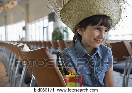 Stock Image - Hispanic girl sitting in airport. Fotosearch