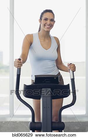 Stock Photo - Hispanic woman exercising in health club. Fotosearch