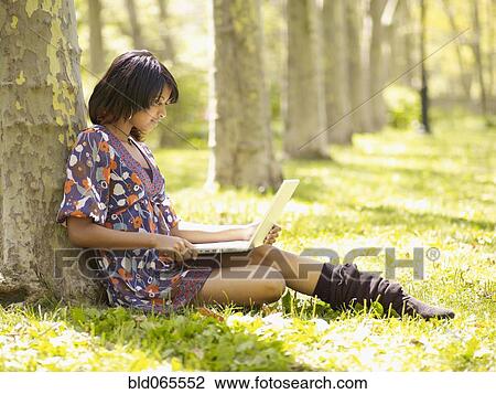 Hispanic woman typing on laptop in park View Large Photo Image Stock Image - Hispanic woman typing on laptop in park. Fotosearch