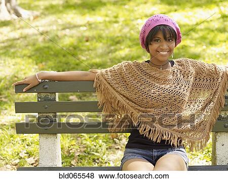 Stock Photo - Hispanic woman wearing cap and shawl in park. Fotosearch