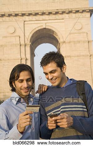 Stock Photo - Indian friends with cell phone and credit card near the India Gate. Fotosearch