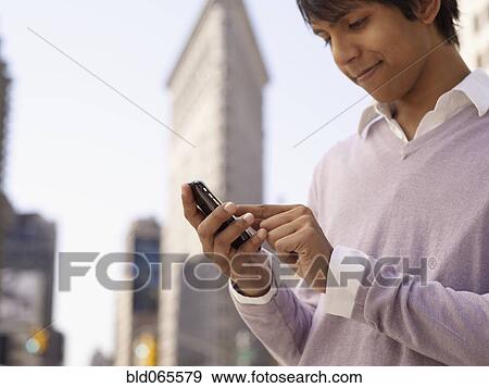 Indian man text messaging on cell phone View Large Photo Image Stock Photo - Indian man text messaging on cell phone. Fotosearch