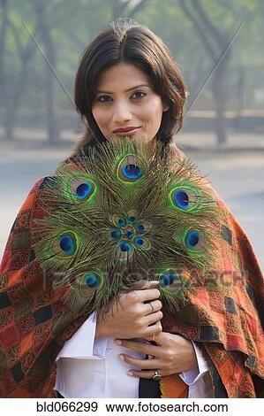 Stock Photo - Indian woman holding peacock feather fan. Fotosearch