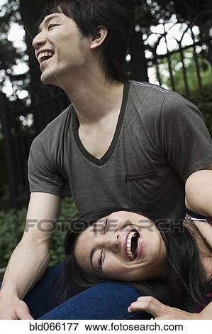 Japanese couple laughing in park View Large Photo Image Stock Photo - Japanese couple laughing in park. Fotosearch