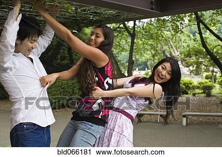 Stock Image - Japanese friends playing outdoors. Fotosearch