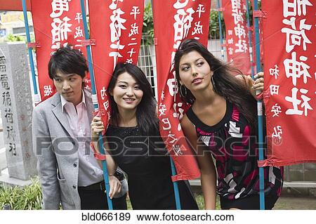 Stock Photo - Japanese friends posing with flags. Fotosearch