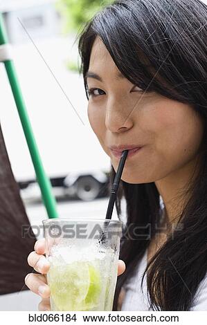 Japanese woman drinking juice with straw View Large Photo Image Picture - Japanese woman drinking juice with straw. Fotosearch