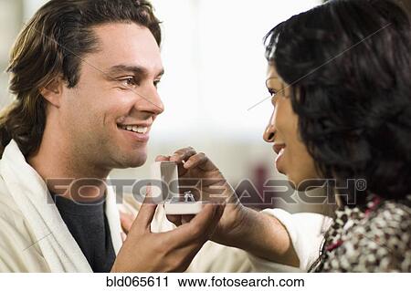 Stock Image - Man giving girlfriend engagement ring. Fotosearch