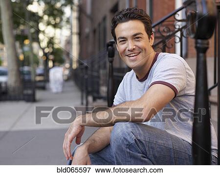 Stock Photo - Man sitting on front stoop. Fotosearch