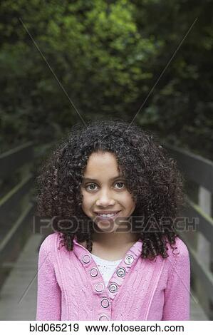 Mixed race girl crossing wooden bridge View Large Photo Image Stock Photo - Mixed race girl crossing wooden bridge. Fotosearch