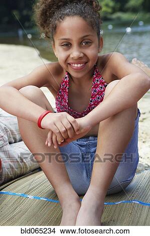 Mixed race girl relaxing near lake View Large Photo Image Picture - Mixed race girl relaxing near lake. Fotosearch