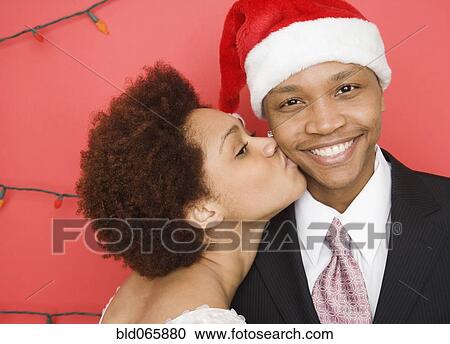Mixed race woman kissing boyfriend in santa hat View Large Photo Image Stock Image - Mixed race woman kissing boyfriend in santa hat. Fotosearch