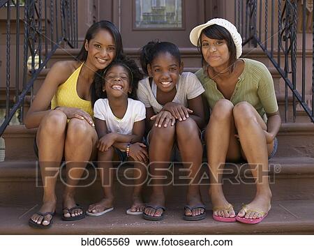 Stock Photo - Mothers and daughters sitting on front stoop. Fotosearch