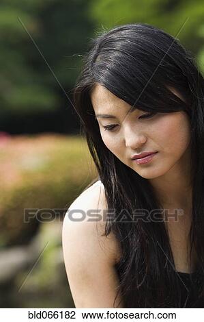 Stock Image - Sad Japanese woman looking down. Fotosearch