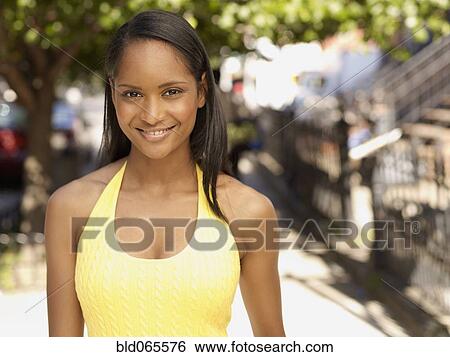 Stock Photograph - Smiling African woman outdoors. Fotosearch