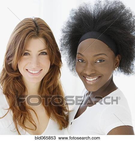 Stock Image - Smiling Caucasian and African woman. Fotosearch