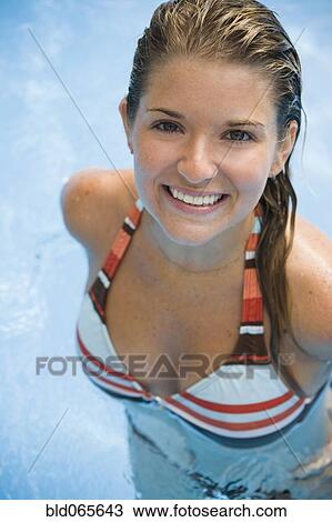 Stock Image - Smiling Hispanic woman standing in swimming pool. Fotosearch
