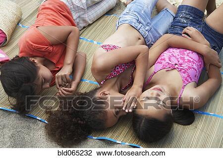 Stock Image - Young girl friends sharing secrets. Fotosearch