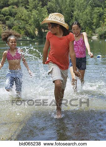 Young girls splashing in lake View Large Photo Image Stock Photo - Young girls splashing in lake. Fotosearch