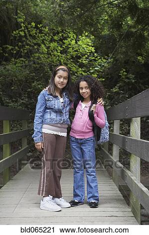 Young school girls posing on wooden bridge View Large Photo Image Stock Image - Young school girls posing on wooden bridge. Fotosearch