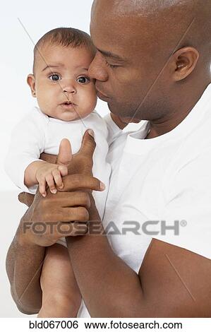 Stock Photograph - African father holding baby daughter. Fotosearch