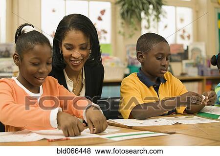 African school teacher helping students View Large Photo Image Stock Photo - African school teacher helping students. Fotosearch