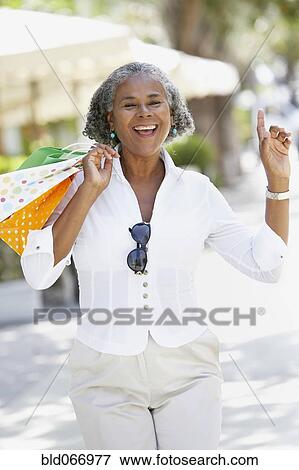 African woman carrying shopping bags and dancing View Large Photo Image Stock Photo - African woman carrying shopping bags and dancing. Fotosearch