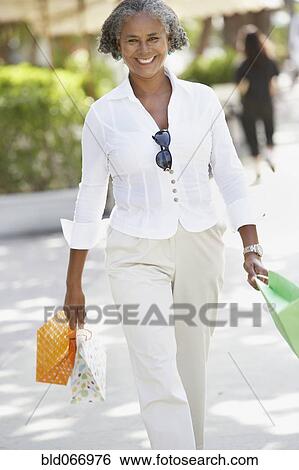 Stock Photograph - African woman carrying shopping bags. Fotosearch