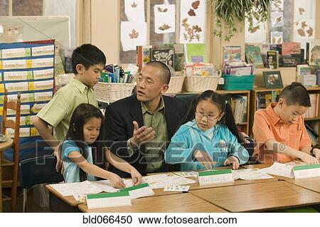 Asian school teacher helping students View Large Photo Image Stock Image - Asian school teacher helping students. Fotosearch