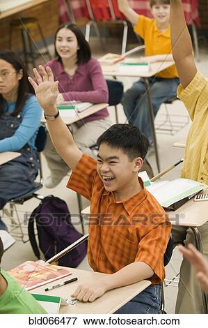 Stock Photo - Asian student raising hand in classroom. Fotosearch