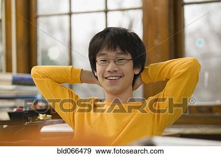 Stock Photo - Asian student relaxing in classroom. Fotosearch