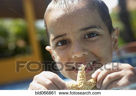 Boy holding starfish in swimming pool View Large Photo Image Stock Image - Boy holding starfish in swimming pool. Fotosearch