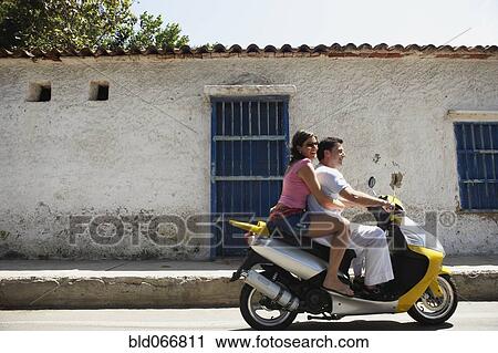 Couple riding scooter View Large Photo Image Stock Image - Couple riding scooter. Fotosearch