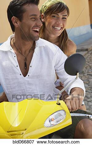 Stock Photo - Couple riding scooter. Fotosearch