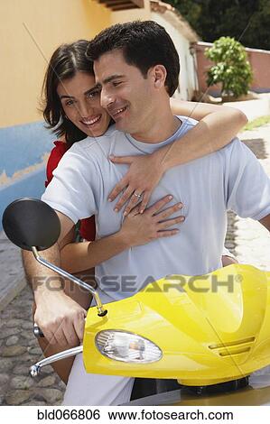 Stock Photograph - Couple riding scooter. Fotosearch