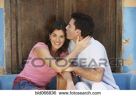 Stock Photograph - Couple sitting with suitcase. Fotosearch