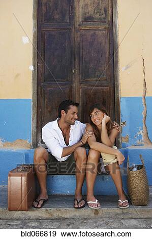 Stock Photo - Couple sitting with suitcases. Fotosearch